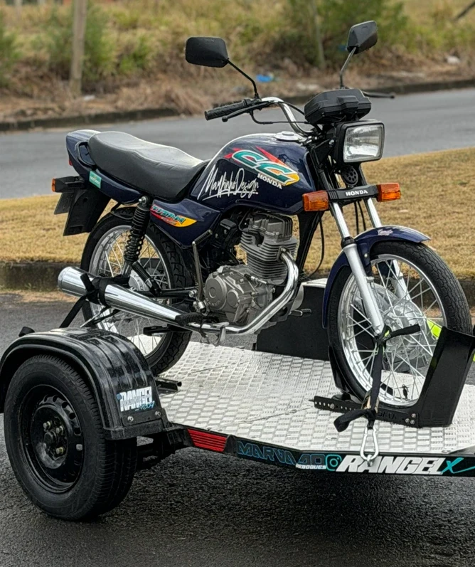 Titan azul em ângulo dianteiro de 3/4, com leitura de tanque, farol, motor e roda dianteira